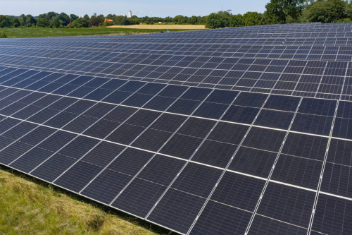 Nahe Luftaufnahme der Solarmodulfläche mit Wasserturm am Horizont